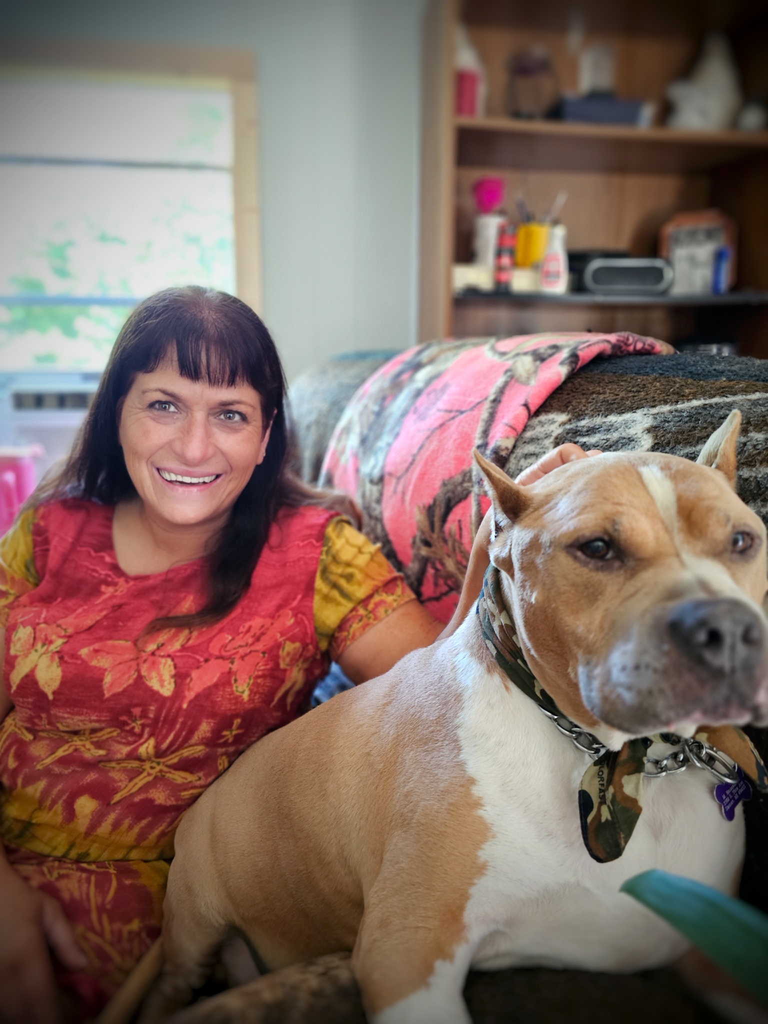 Woman in a pink shirt sitting with her dog Otis.