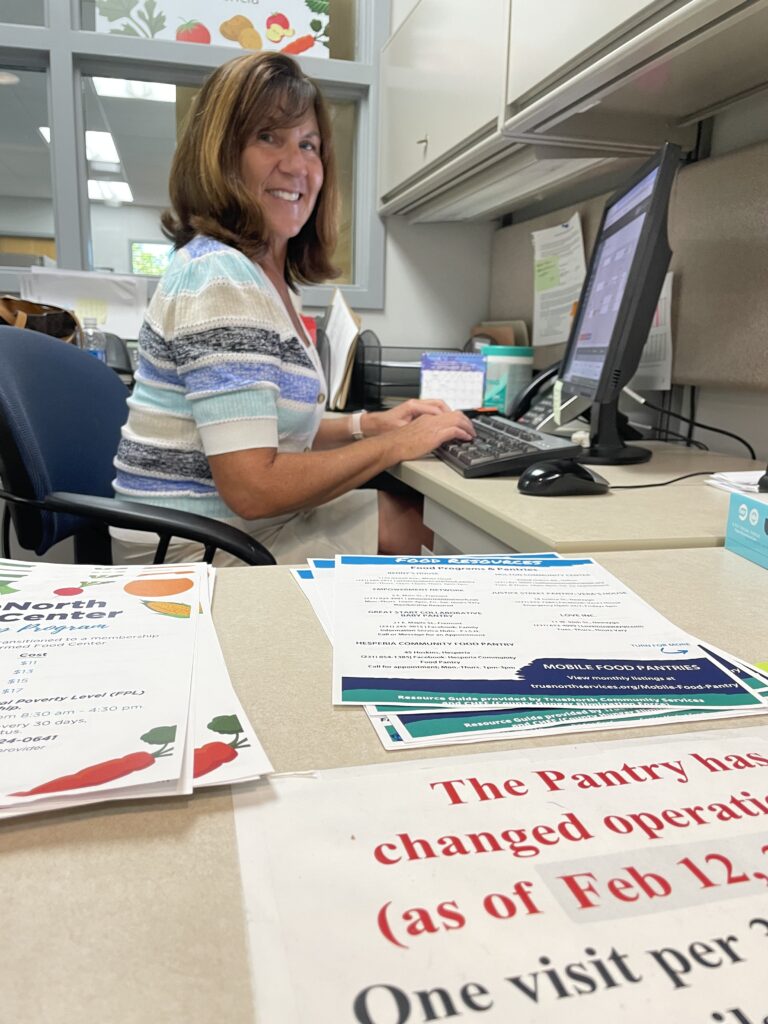 Woman sitting at a desk and smiling.