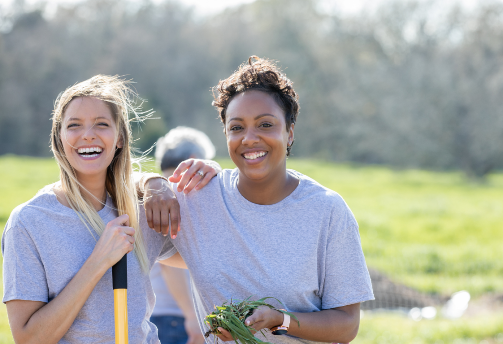 Two women smiling in a garden.