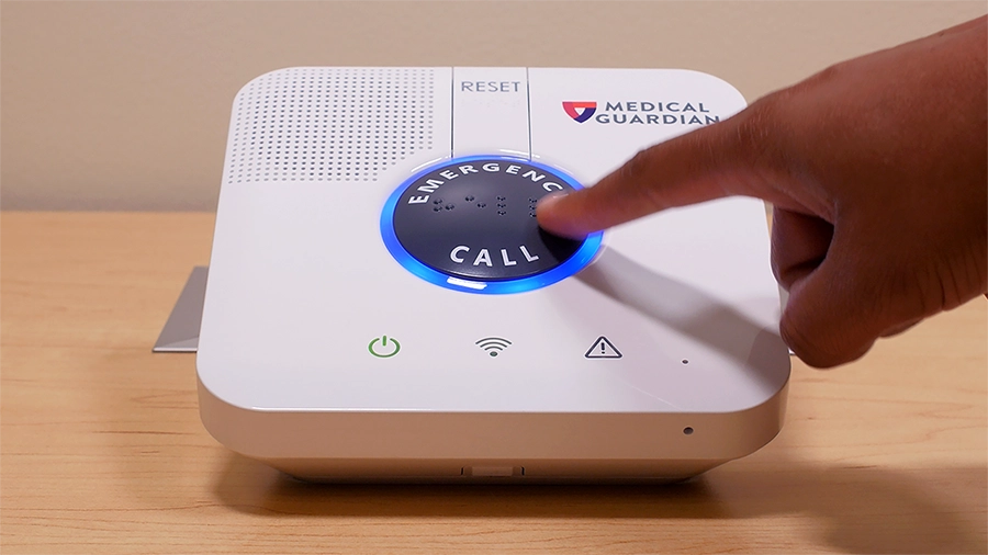 Medical guardian machine with the emergency call button being pressed