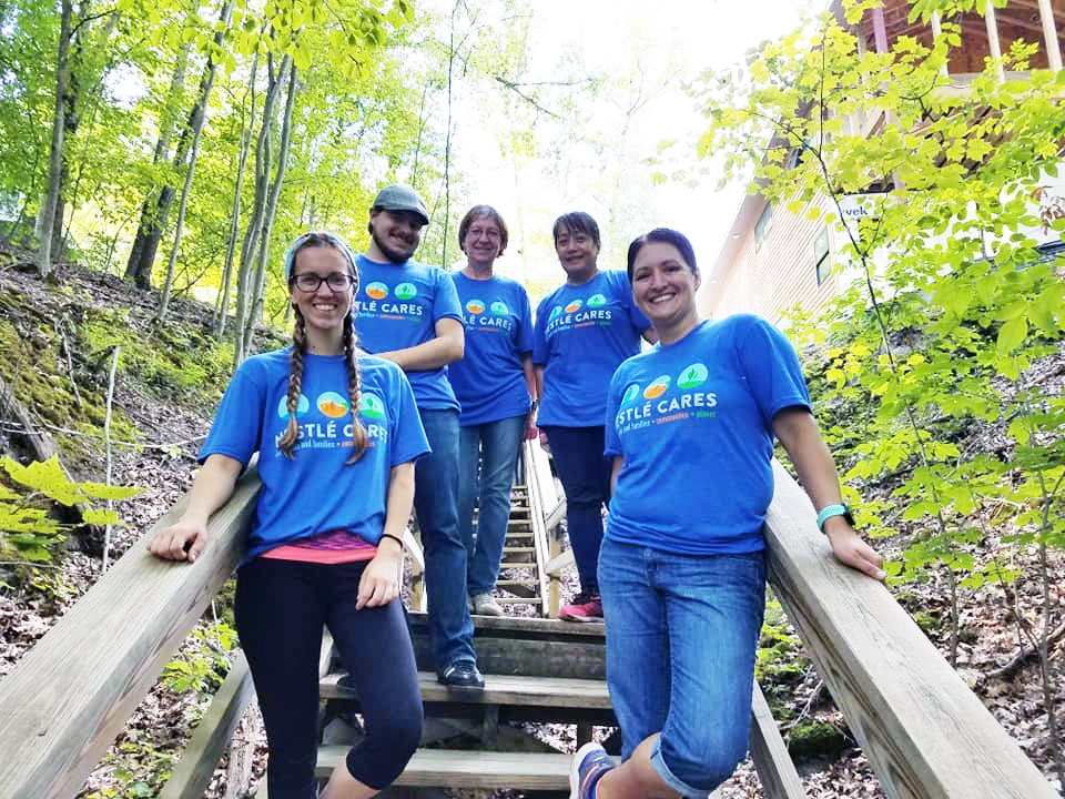 A group of Nestle Care volunteers on the steps at Camp Newaygo