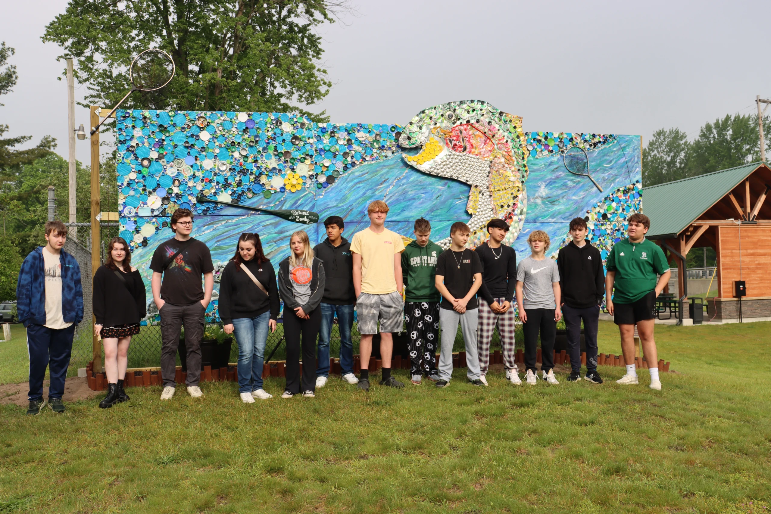13 student artists in front of the outdoor mural in Hesperia