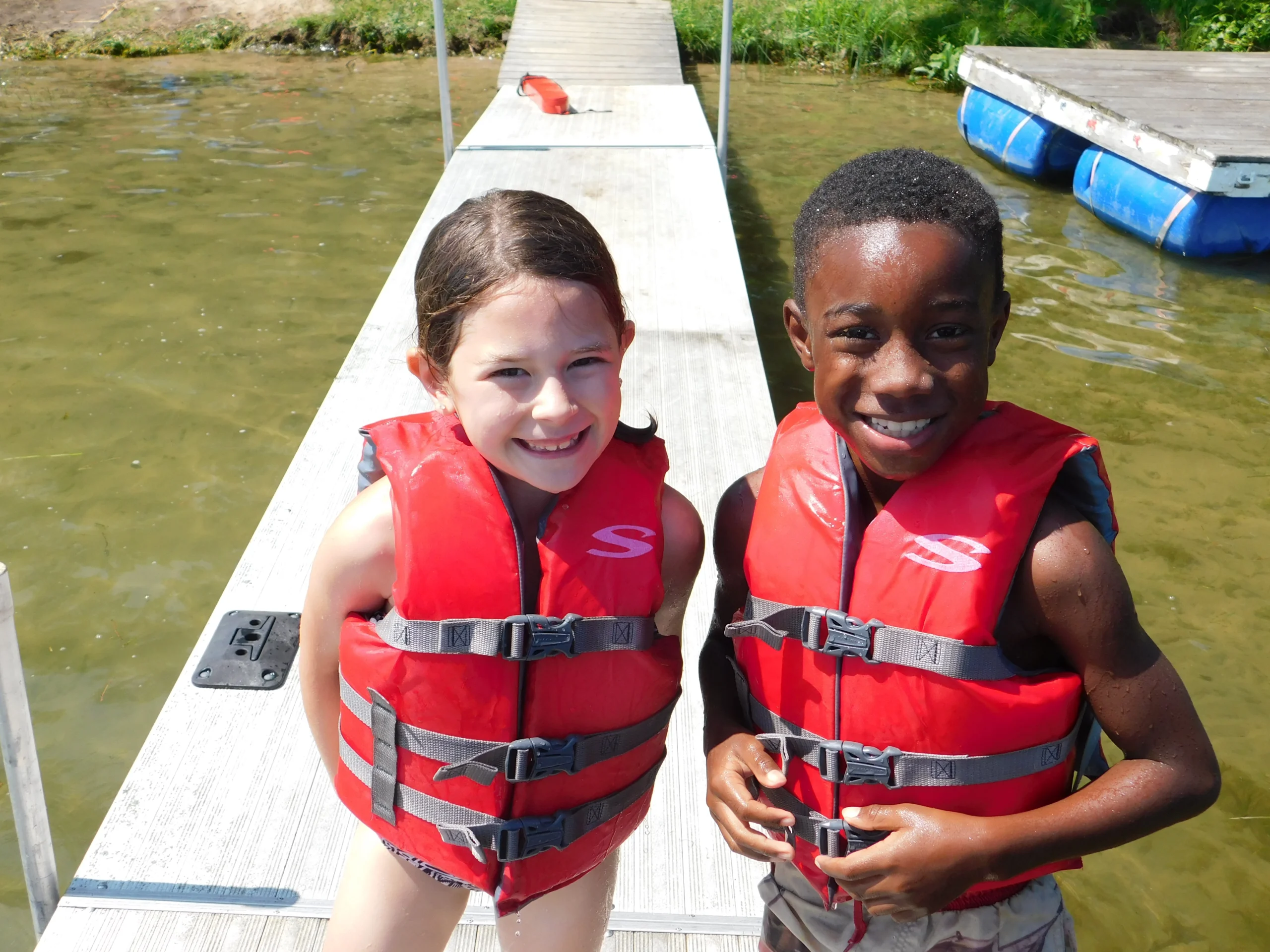 A young girl and a young boy in lifejackets at Day Camp at Camp Newaygo