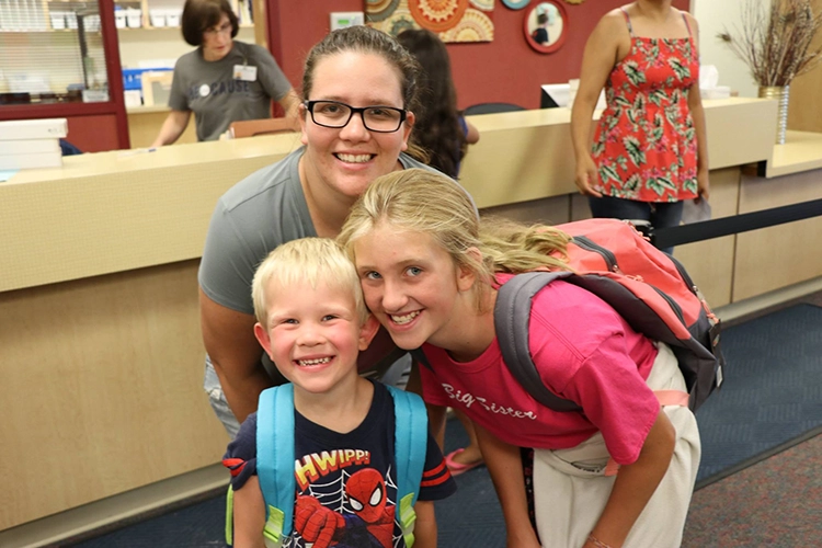 A family smiling with their new backpacks.