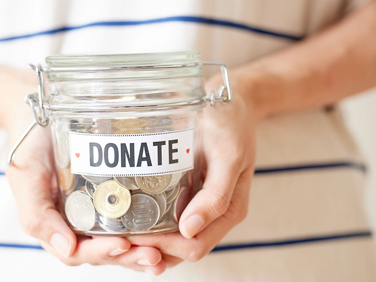 Hands holding a jar that says donate.