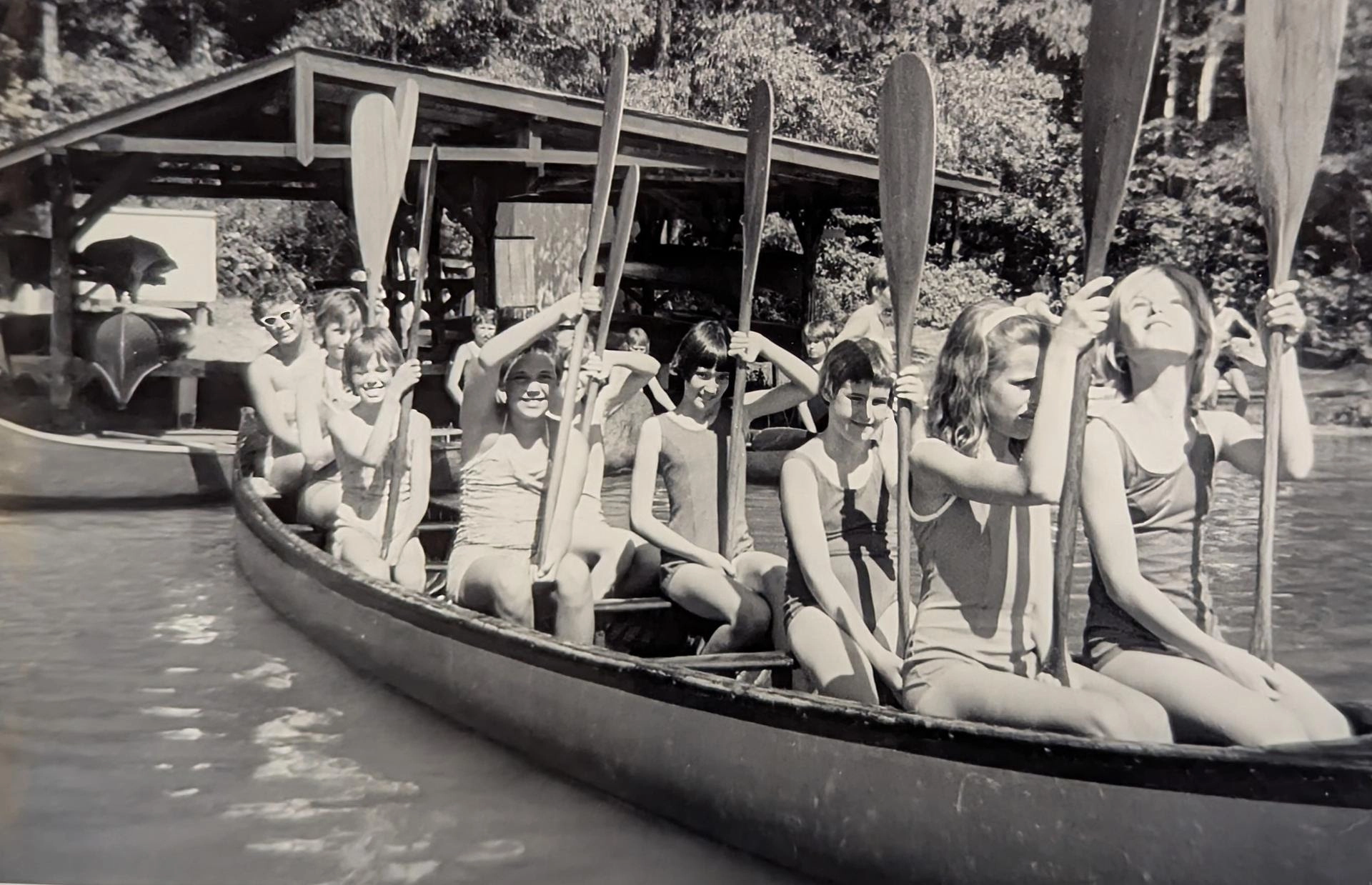Old black and white photo of several young girls in large canoe at Camp Newaygo