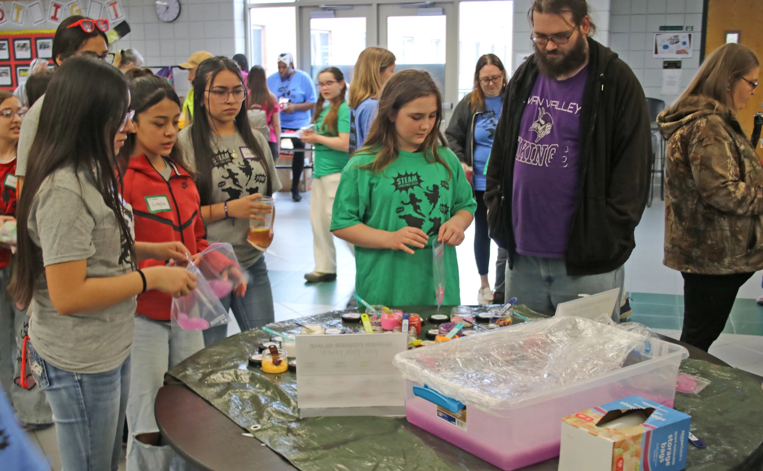 4 students and 1 adult at an activity table at the 2026 STEAM Challenge