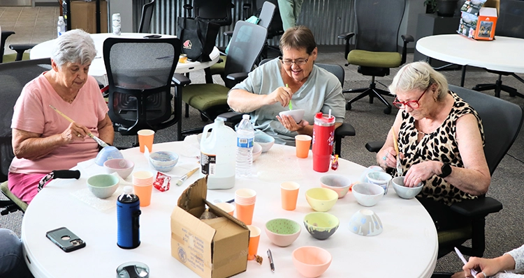 older adults from Community Connections glazing bowls for Empty Bowls